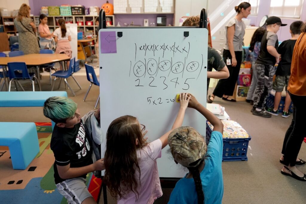 students drawing on white board