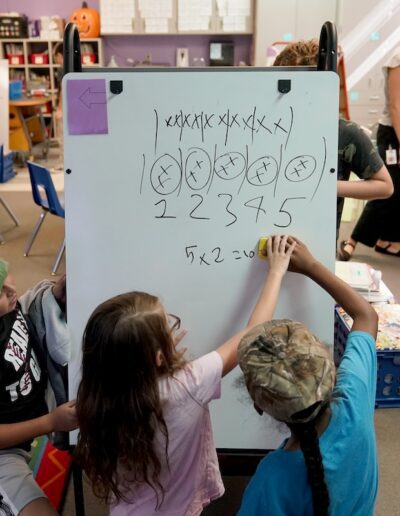 students drawing on white board