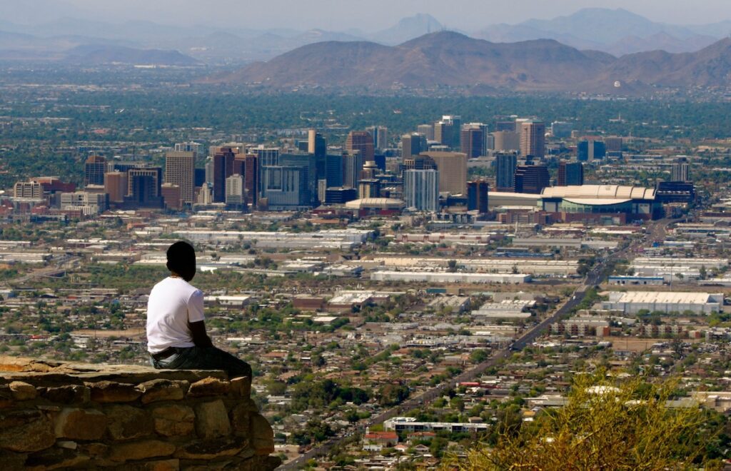 man sitting looking out over Phoenix skyline