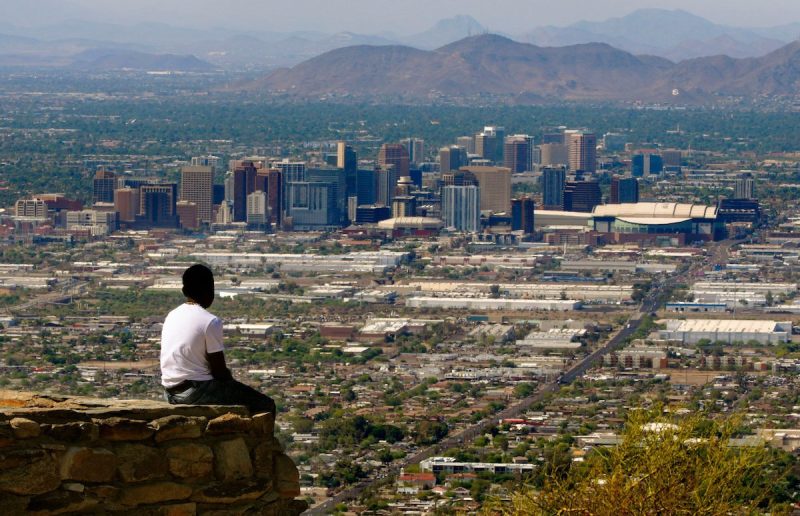 man sitting looking out over Phoenix skyline