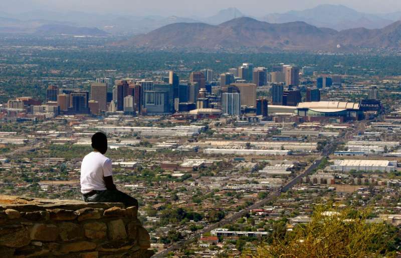 man sitting looking out over Phoenix skyline