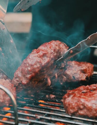 spatula flipping burgers on a smoky grill