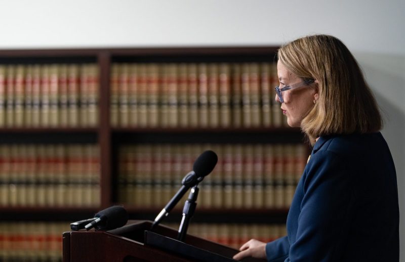 Mayes speaking into mic