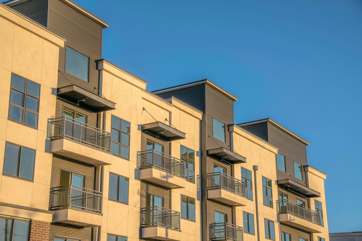 Phoenix, Arizona- Apartment building with metal wall cladding and balconies. Front exterior of a modern residential building against the blue sky.