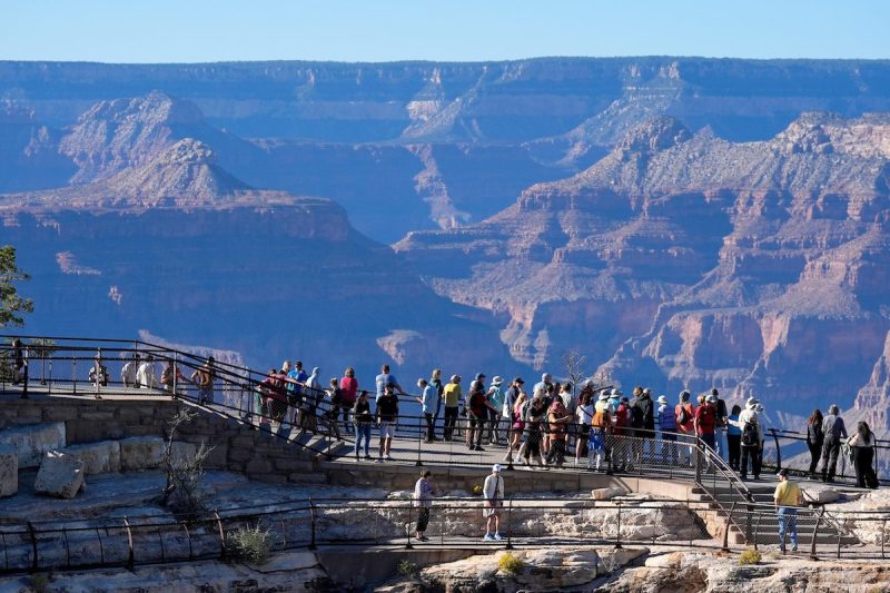 large group of people standing on the edge of the Grand Canyon