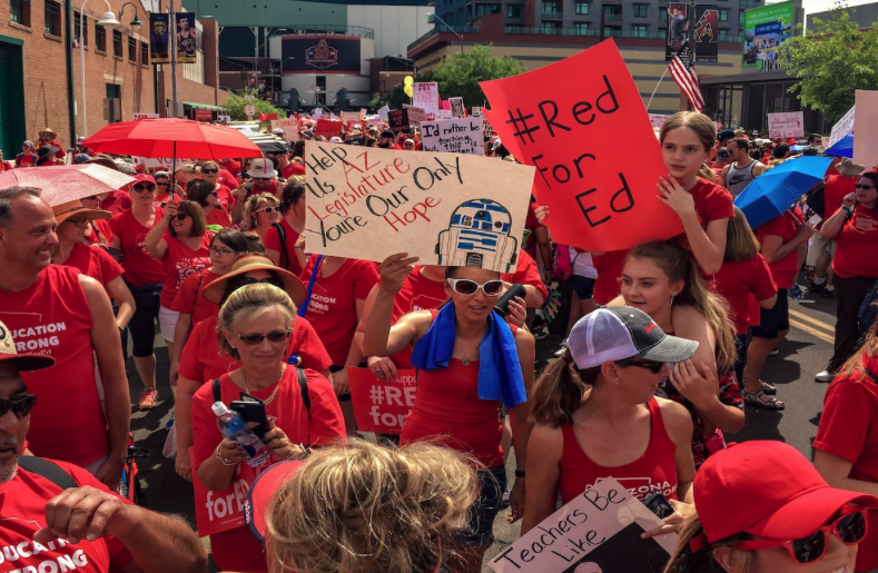 people wearing red and marching with signs that say Red for Ed