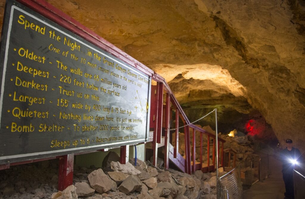 a sign outside a hotel room located in a dark cavern