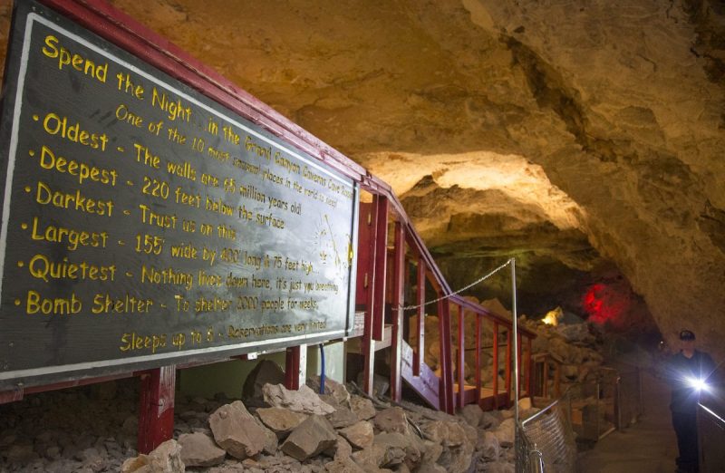 a sign outside a hotel room located in a dark cavern