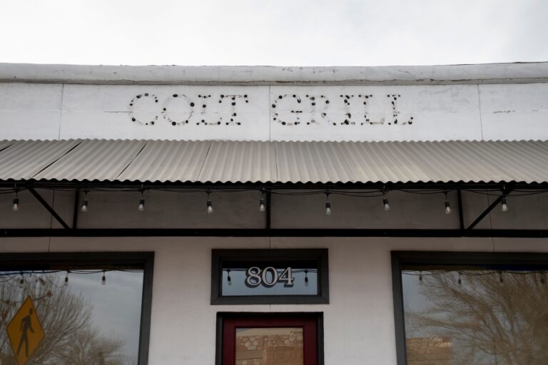 the outline of letters spelling Colt Grill on a building facade