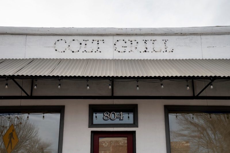 the outline of letters spelling Colt Grill on a building facade