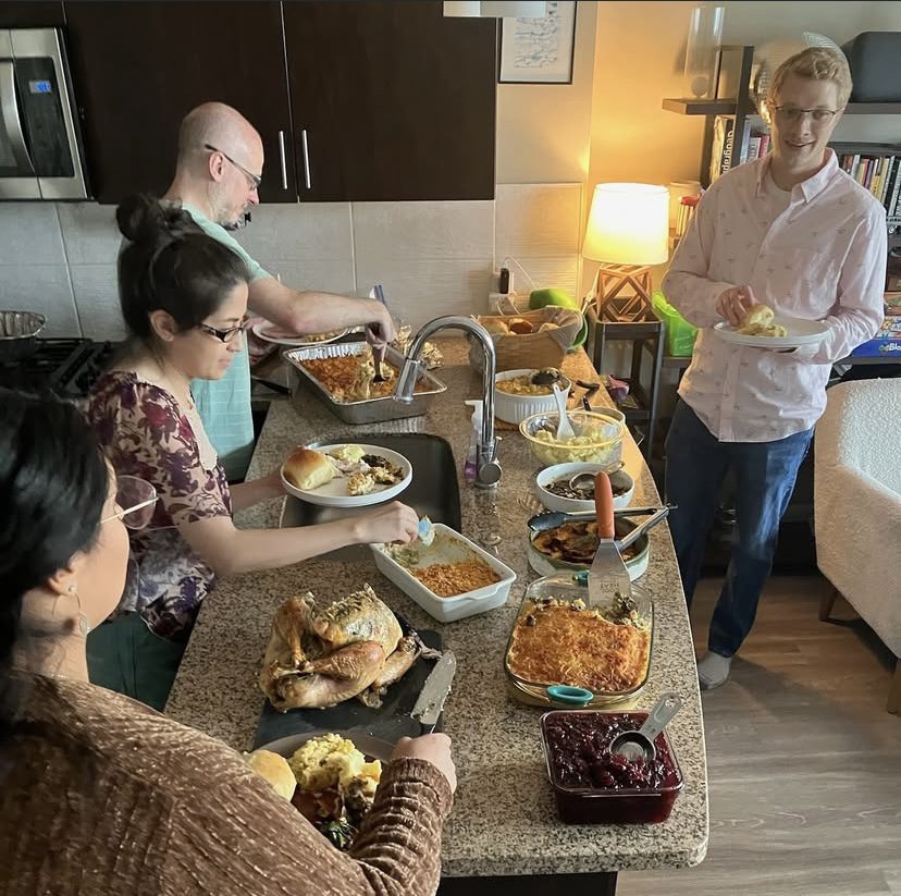 people serving themselves form dishes on a table