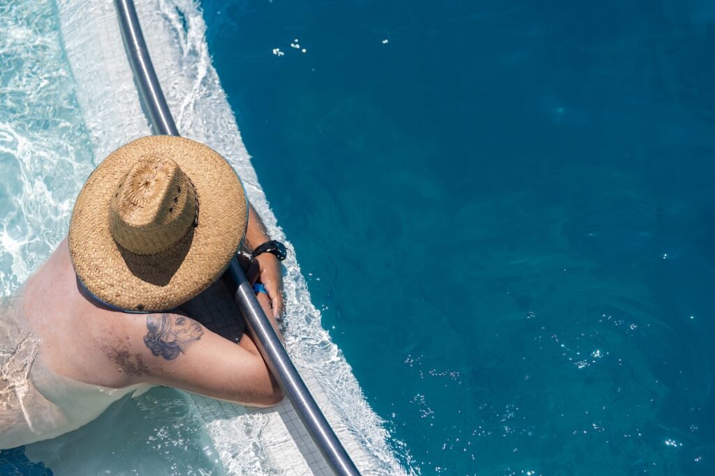 aerial view of a man lying against a railing in a pool