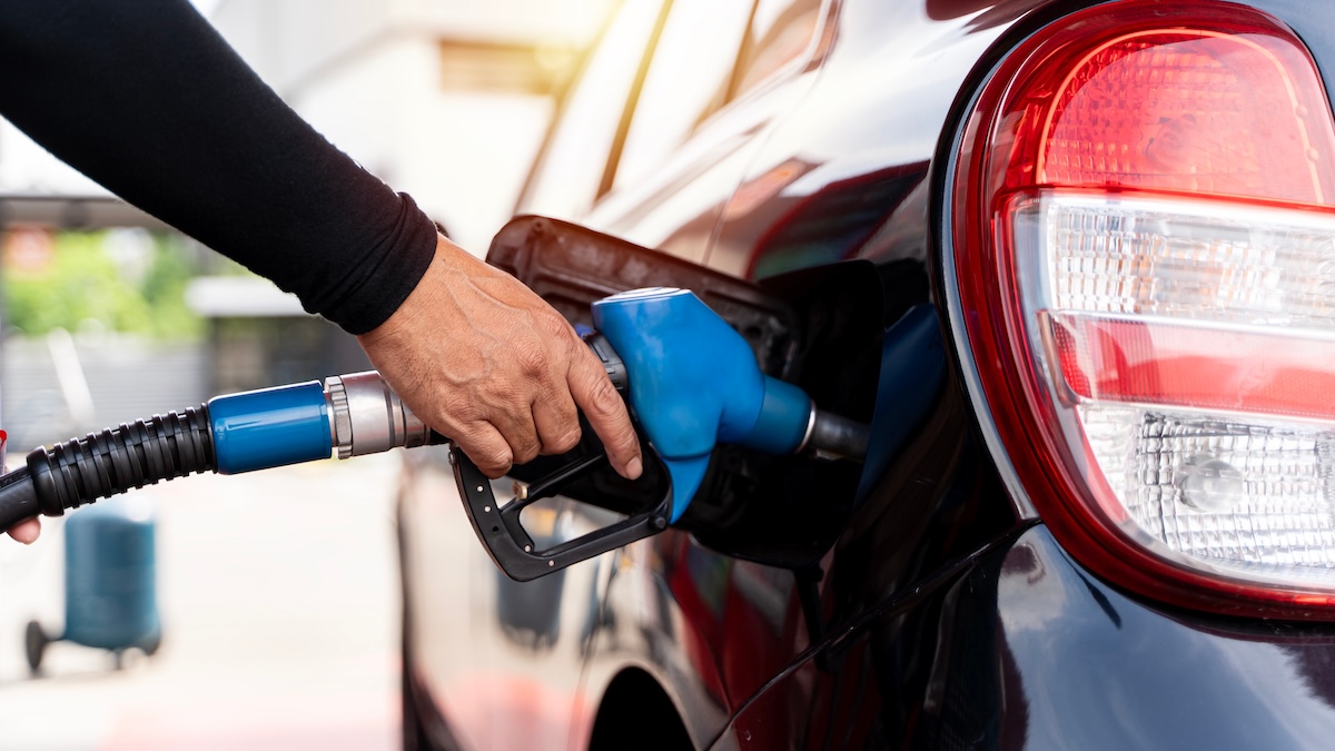 hand holding gas pump in car