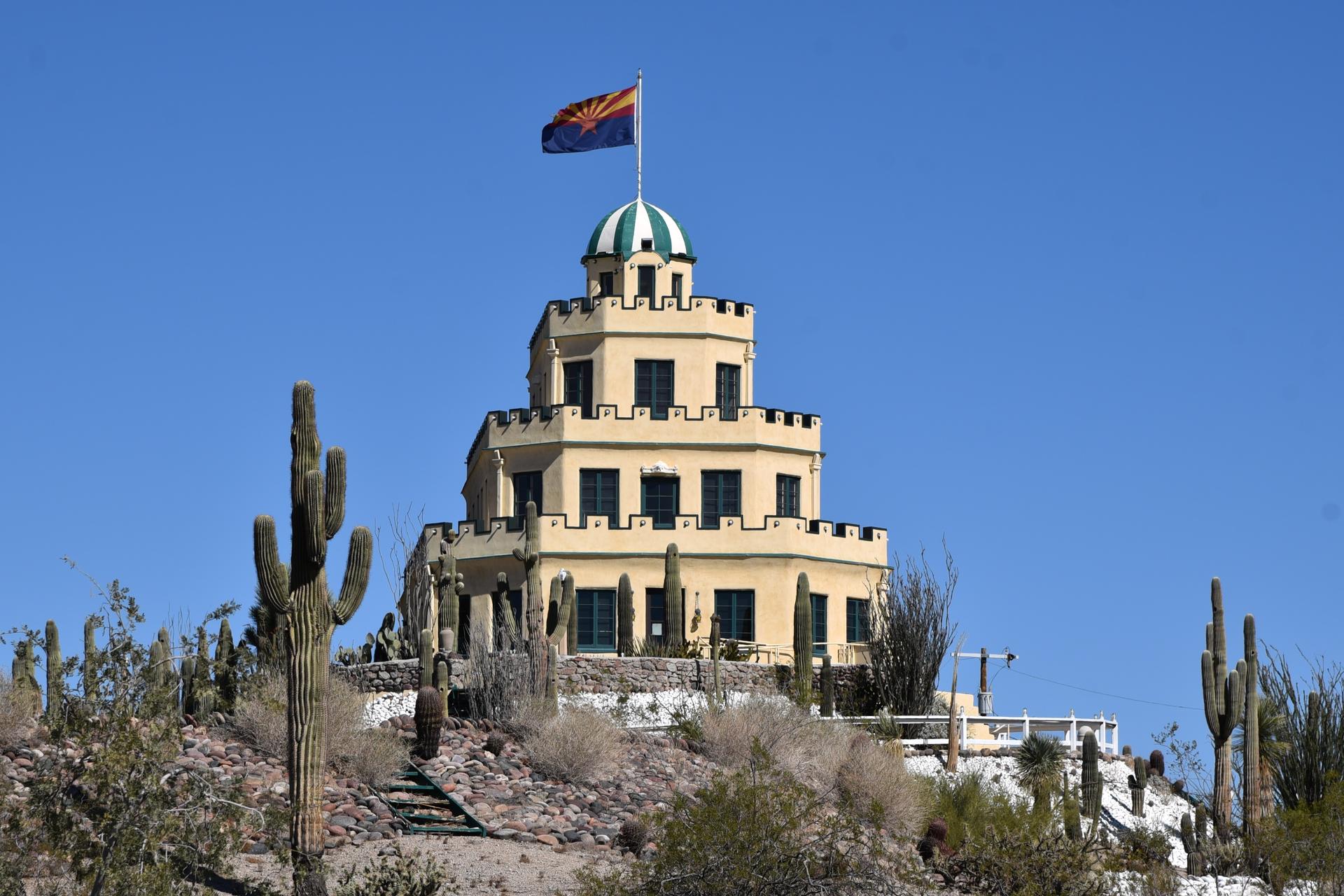 a castle-like building against a blue sky and desert landscape