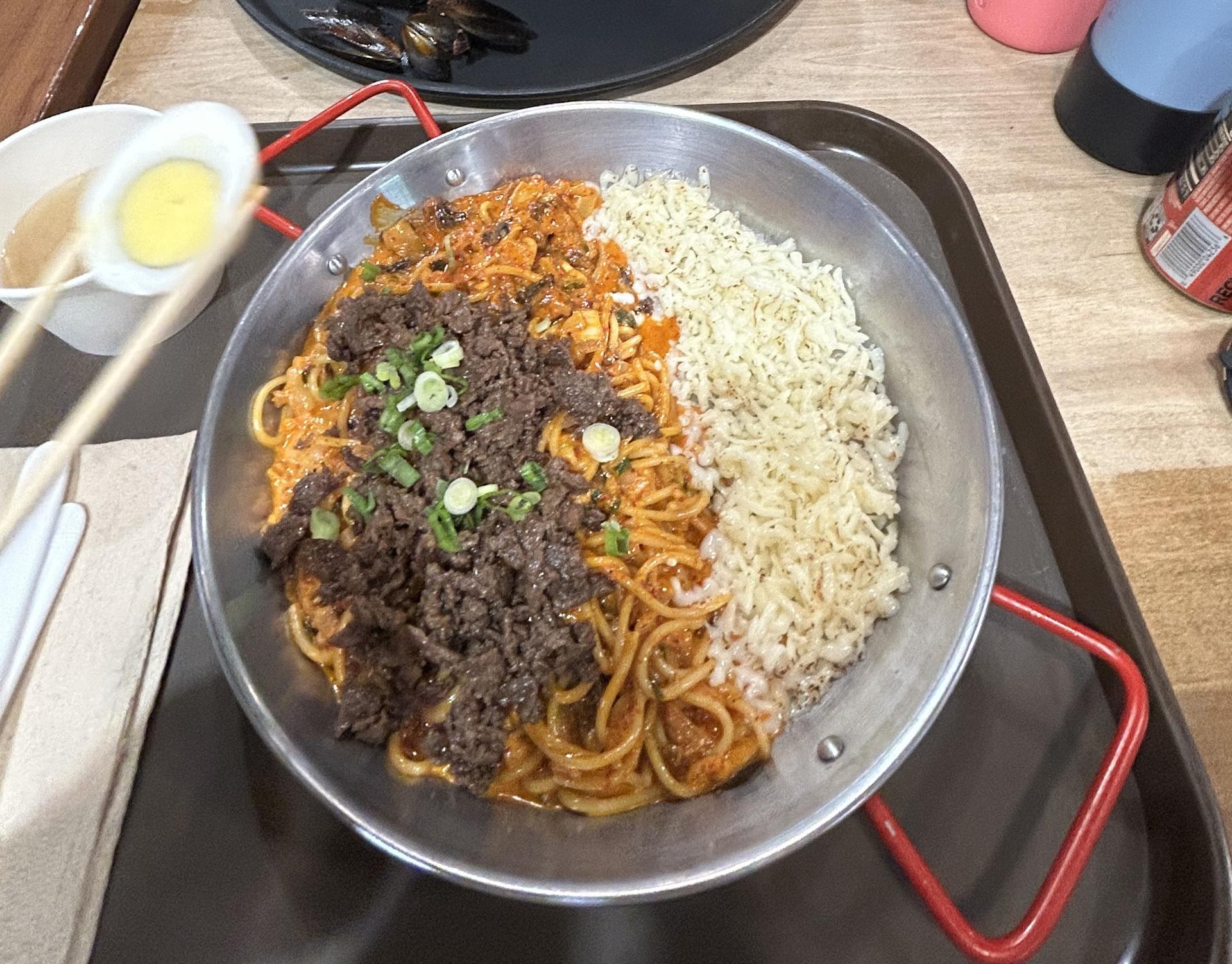 bowl of pasta with meat on top and white cheese