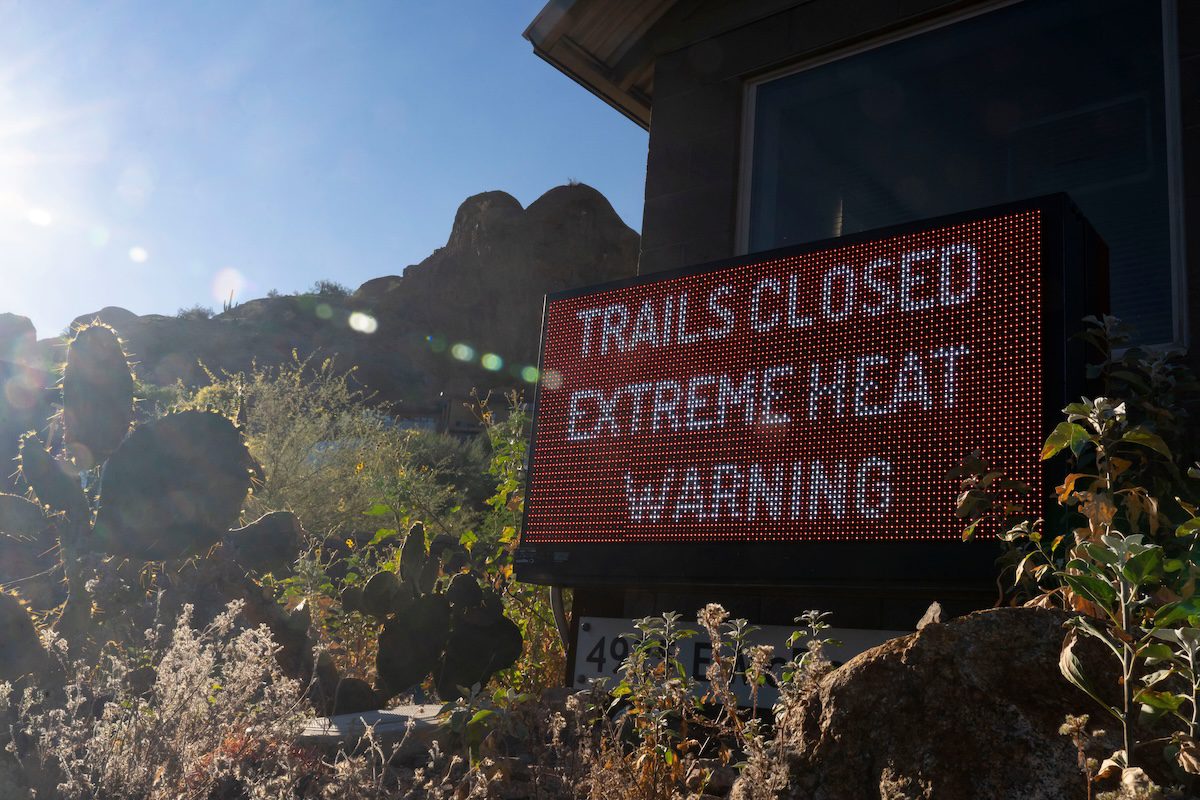 A sign warns hikers of trail closures due to extreme heat