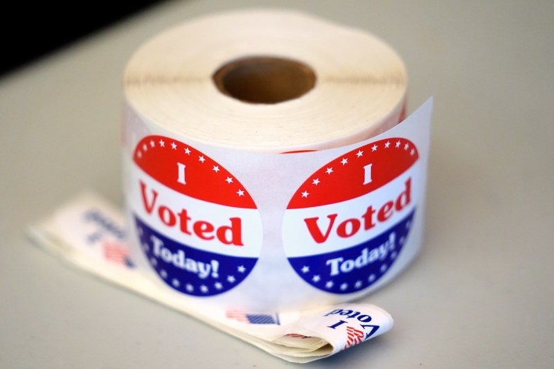 A spool of I Voted stickers rests on a table at a polling station