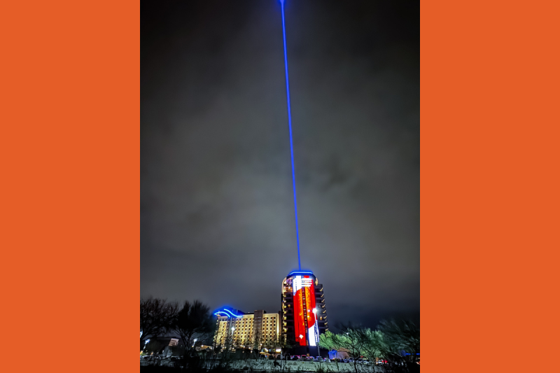 a blue beam shining up from a high-rise building