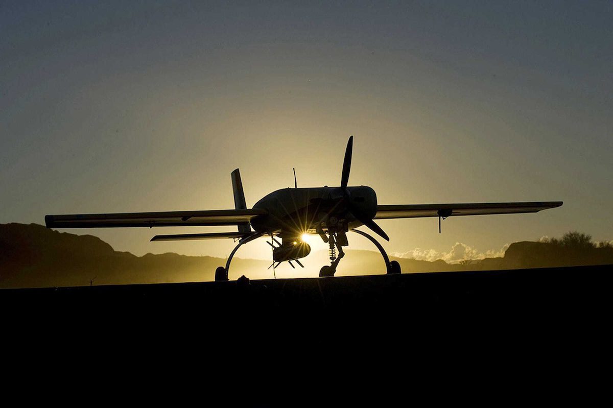the silhouette of a missile plane in front of a sunset