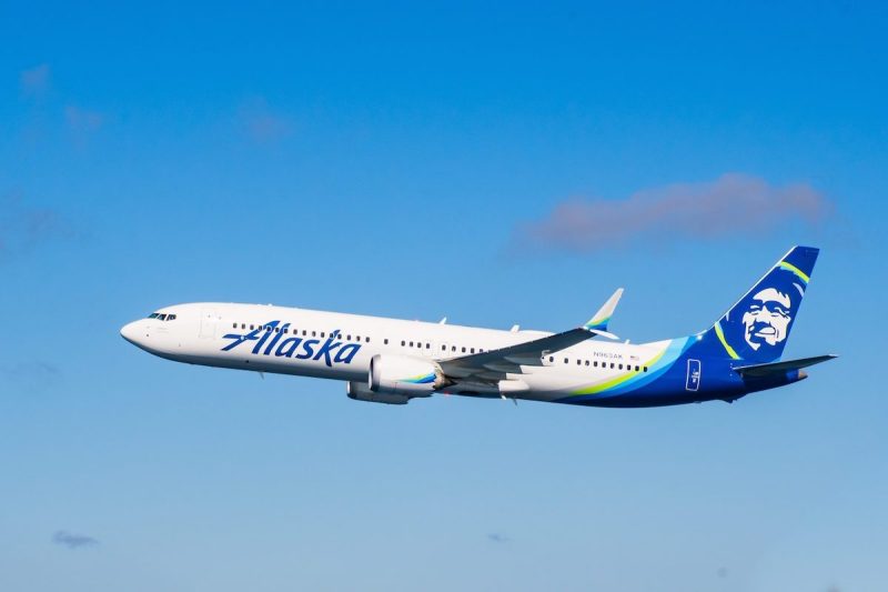 Alaska Airlines branded plane flying in the sky