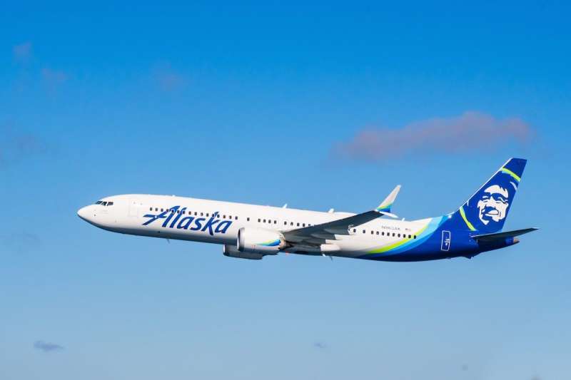 Alaska Airlines branded plane flying in the sky