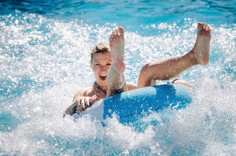 woman on an inner tube in a pool exiting a waterslide