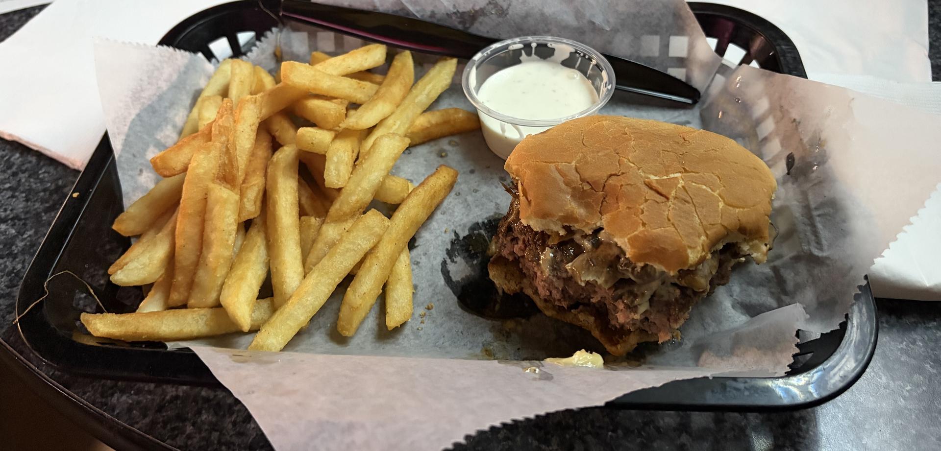 tray with fries and a partially eaten burger