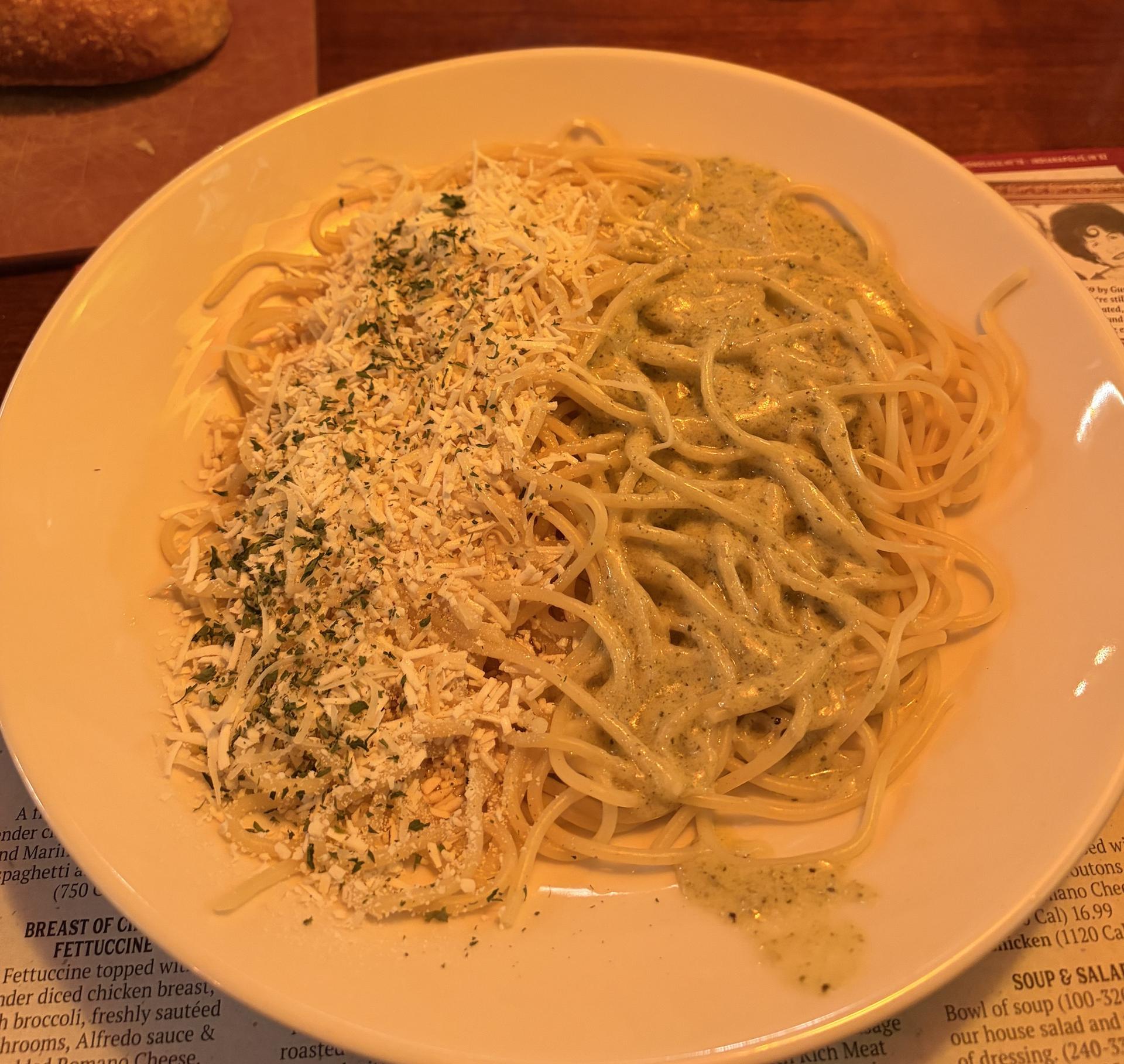 plate of spaghetti with white sauce and shredded cheese