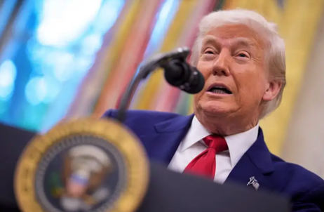 Trump speaking into a mic