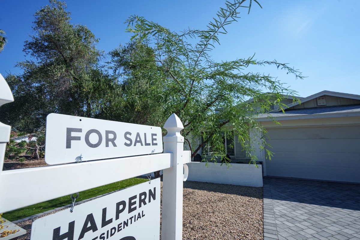a for sale sign in front of a home