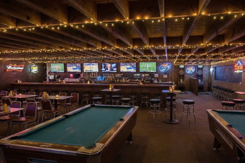 interior of a bar with pool tables and string lights