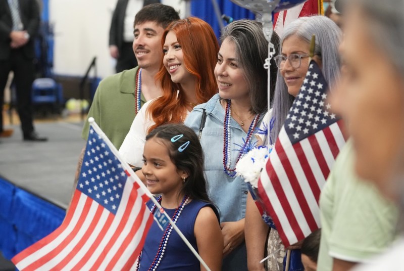 a group of people poses holding American flags