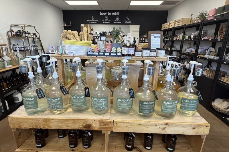 a shelf with multiple pump bottle labeled hand soap inside a store