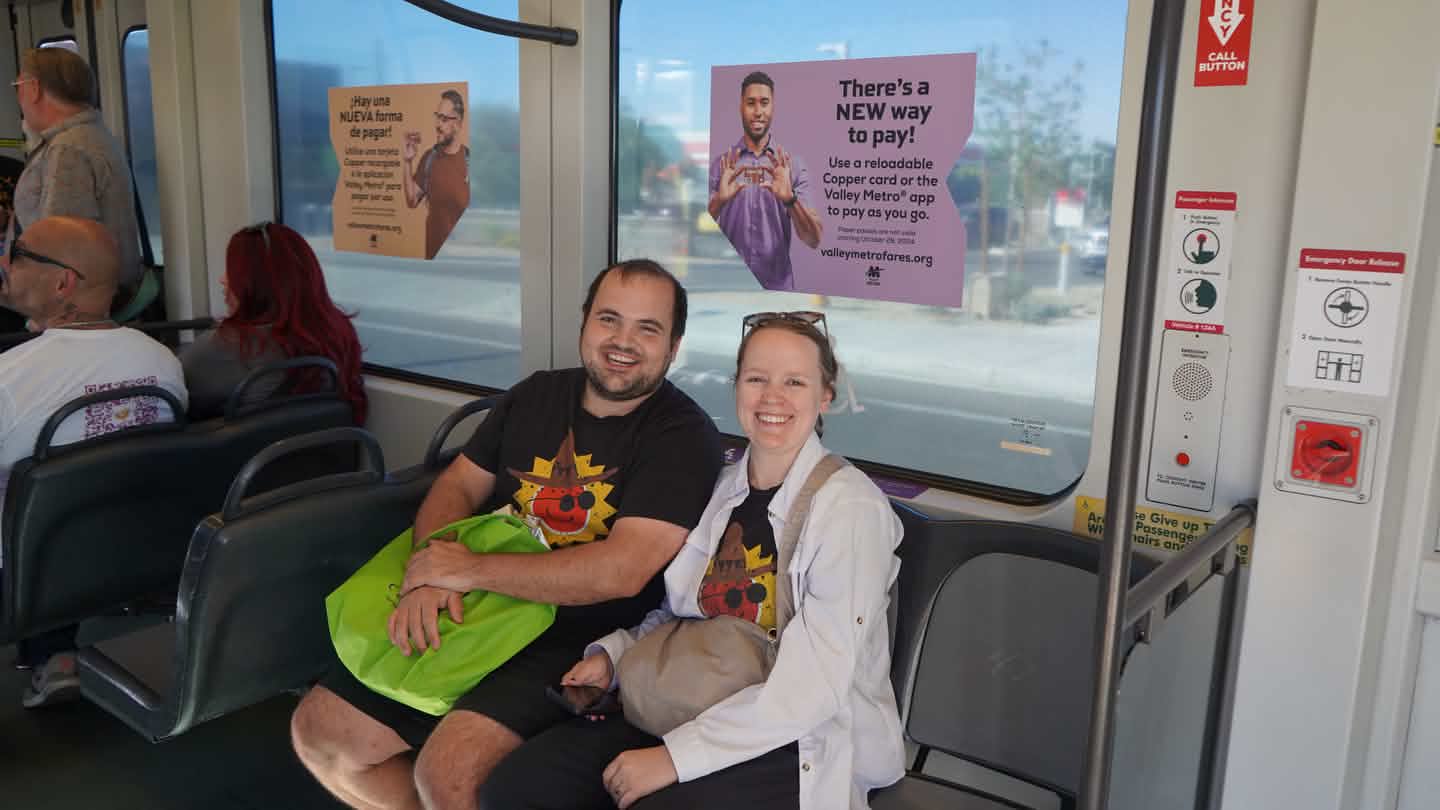 two people sitting on a bench on a light rail