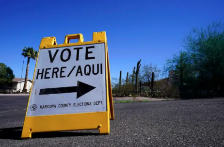 a vote here sign in a parking lot